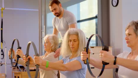 Entrenador-Que-Ayuda-A-Mujeres-Mayores-A-Realizar-Yoga-4k