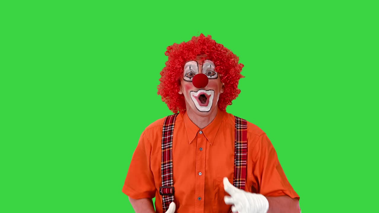 payaso gracioso caminando rápido y haciendo esperar por mí gesto en una pantalla verde, clave de croma