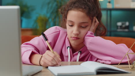 preteen school girl using laptop for online lesson, doing homework, distance learning education