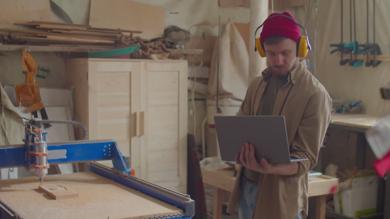 Carpenter Operating Woodworking CNC Machine with Laptop