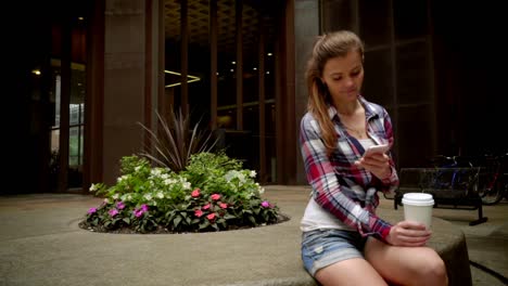 Young-woman-with-phone-and-coffee-cup.-Mobile-woman-sitting-with-coffe-cup