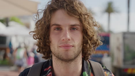 Primer-Plano-Retrato-De-Un-Joven-Apuesto-Mirando-Serio-A-La-Cámara-Atractivo-Turista-Masculino-En-Vacaciones-De-Verano-Fondo-Urbano-Frente-A-La-Playa