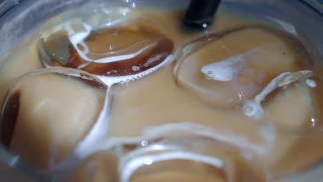 close-up of iced coffee with ice cubes and straw