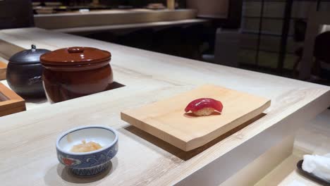 chopsticks pick sushi from wooden board