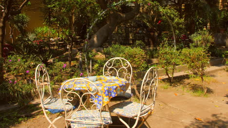 typical italian garden with a round table and chairs on a sunny day