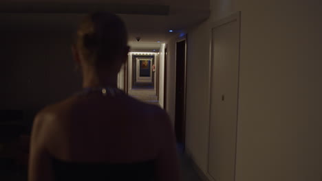 mujer caminando por el pasillo de un hotel por la noche