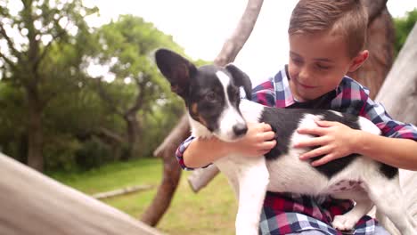 en primer plano, un lindo niño sinvergüenza da a su cachorro un gran abrazo.