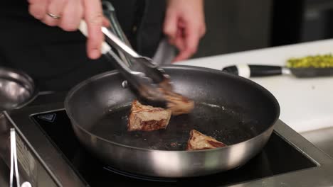 chef searing meat in a pan