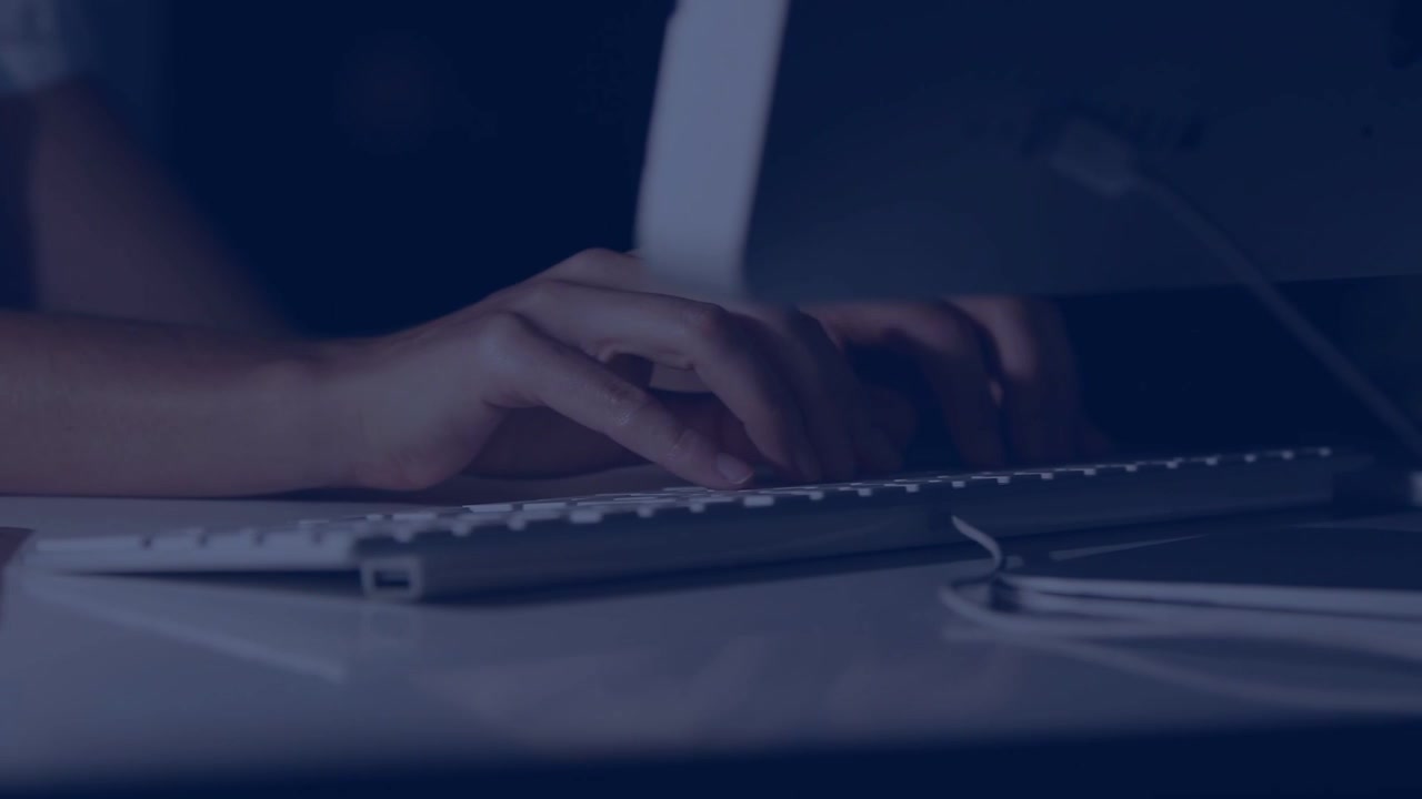 Woman entering frame, typing at IT desk while working, animated overlays fading revealing keyboard