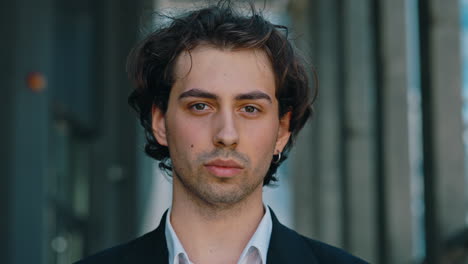 close-up portrait of a young man with dark curly hair