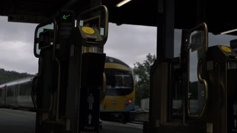 ticket machines as train leaves station wide shot