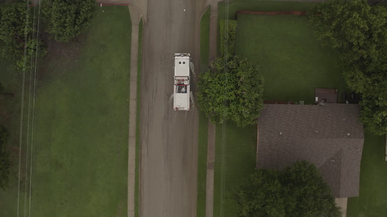 A fire engine slowly passes a red car on a flash flooded street