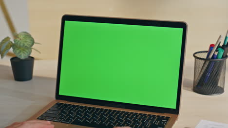 modern green screen laptop placed on desk closeup. empty chroma key computer