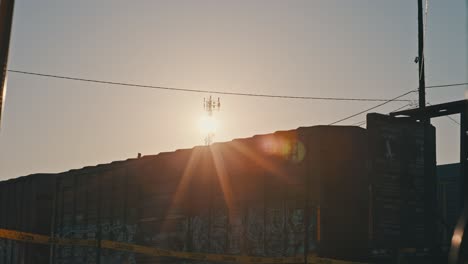freight train moving in slow motion during golden hour with sun flares cinematic