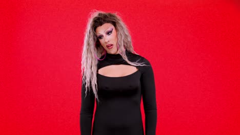 drag queen in black dress against red background