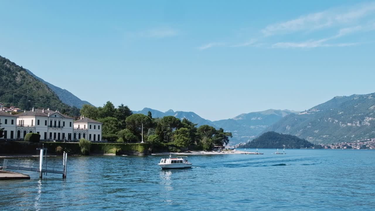 Scenic shot of a boat floating on Como lake near the coastline in Lombardy, Italy