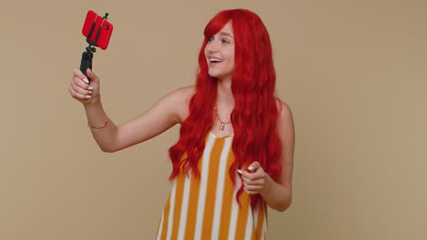 Girl-blogger-take-selfie-on-mobile-phone-selfie-stick-communicate-video-call-online-with-subscribers