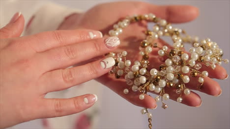 woman's hands holding beautiful pearl and crystal jewelry