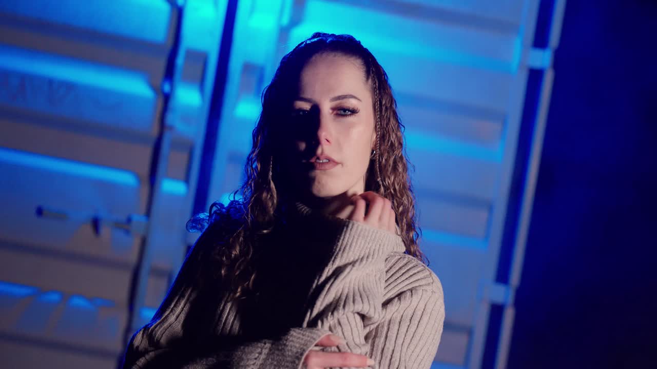 Stylish woman standing in blue fog with a confident and mysterious expression — cinematic lighting and moody atmosphere