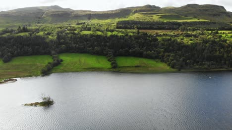 rural scene with meadows and lake surrounded with hills