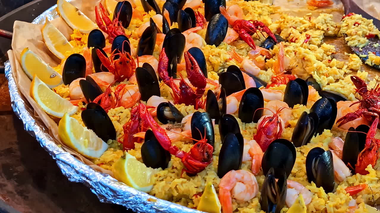 Yellow baked mussel seafodd dish topped with limes and grains prepared for serving