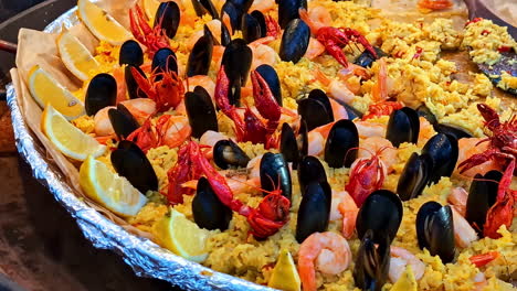 yellow baked mussel seafodd dish topped with limes and grains prepared for serving