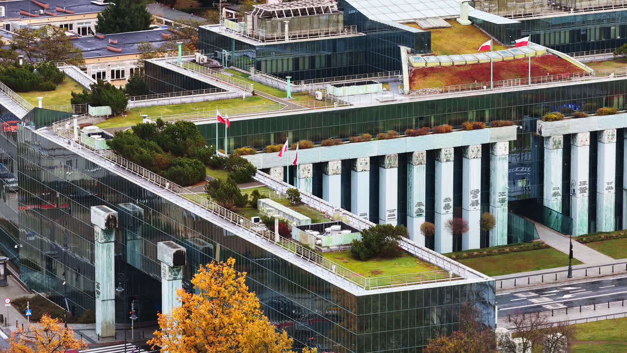 Aerial drone view of the Supreme Court of Poland featuring its distinctive glass structure and green rooftop gardens, located next to Krasinski Square and the Warsaw Uprising Monument