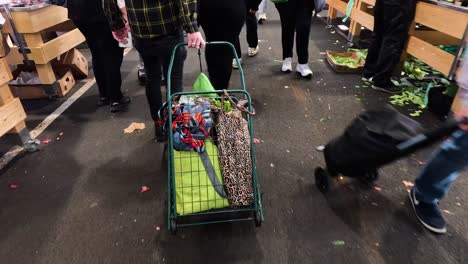 people shopping with carts at a busy market