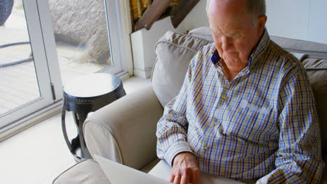 senior man using laptop in living room at home 4k