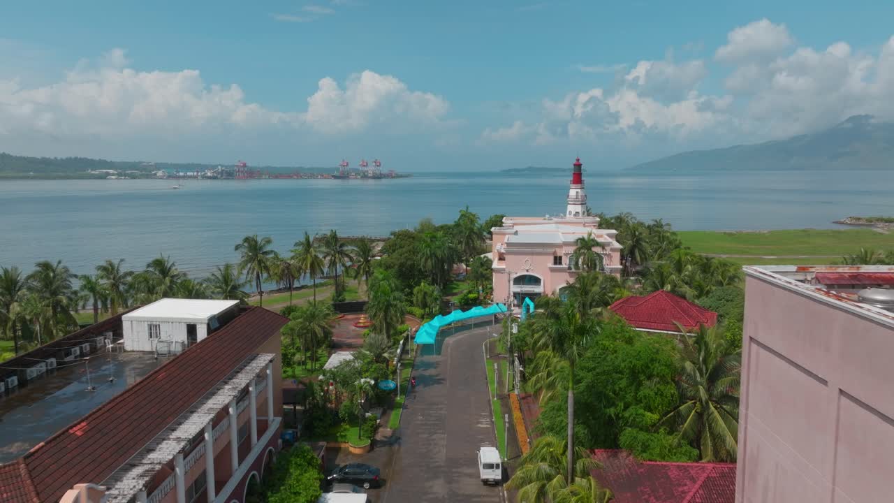 A stunning drone shot captures the vast ocean meeting the shore, with a majestic lighthouse standing tall against the horizon.