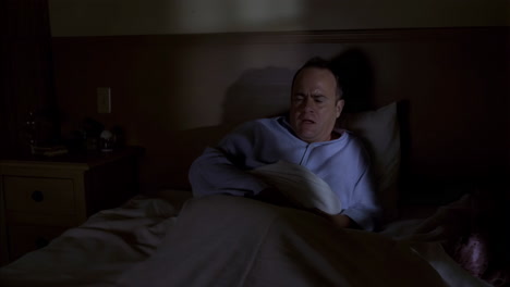 man waking up distressed in bed at night