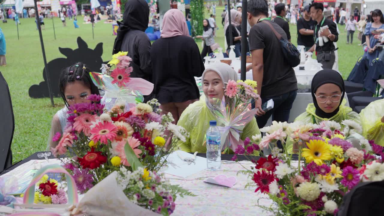 Indonesian Women Crafting Flower Decorations For Outdoor Event In Bogor, Indonesia. medium panning shot