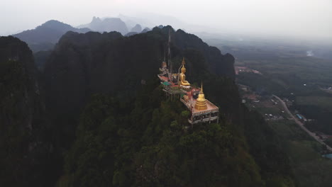 buddhist tiger cave temple on mountain top above thailand countryside