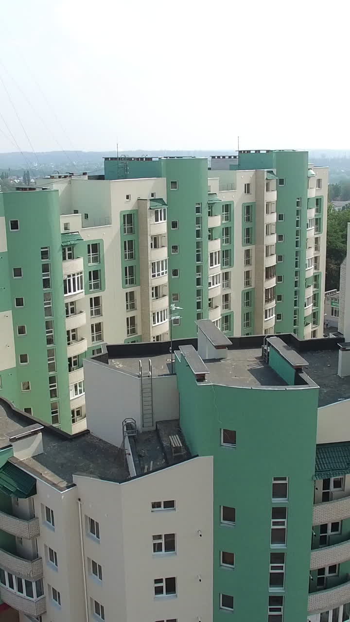Beautiful view opening of a modern building being built in a new residential complex. High-rise house apartment in the city. Motion camera bottom top Vertical video