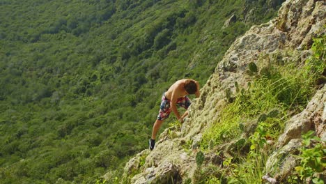 en este video se puede ver a un hombre trepando por la empinada roca en christoffelberg, isla de curacao