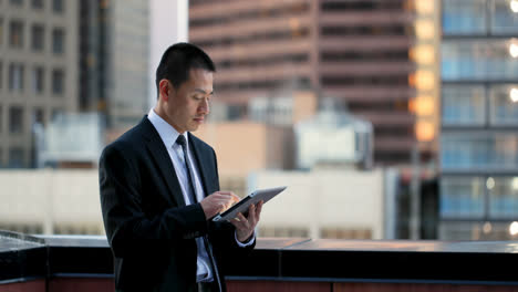 side view of young asian businessman working on digital tablet 4k