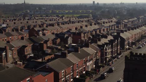 Luftaufnahme-über-Reihen-Historischer-Reihenhäuser-In-Dentons-Green,-St.-Helens,-Mit-Einer-Langen-Straße,-Die-In-Richtung-Des-Geschäftigen-Stadtzentrums-Führt