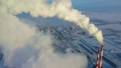 industrial complex in a snowy landscape, emitting smoke