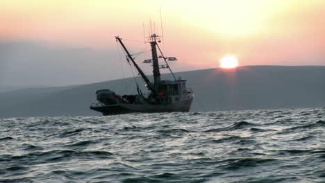 a fishing vessel navigates just off shore