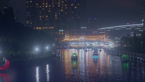 Wunderschöner-Romantischer-Nachtparkblick-Mit-Fluss-In-Den-Stadtlichtern-Und-Booten-Aus-Der-Vogelperspektive