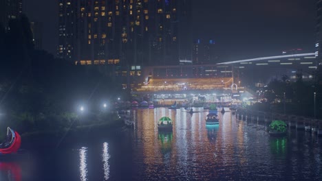 hermosa vista romántica del parque nocturno con el río en la ciudad luces de la ciudad y barcos vista de alto ángulo