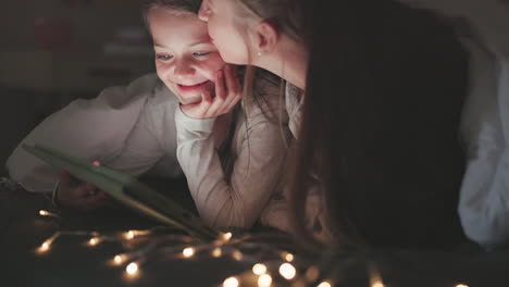 tableta, amor y madre con hija en el dormitorio