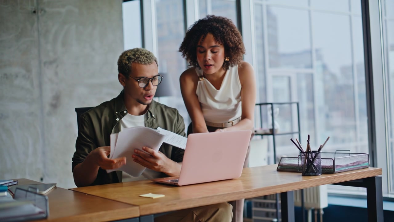 Coworkers reacting bad news laptop desk. Man woman worried analyzing documents.