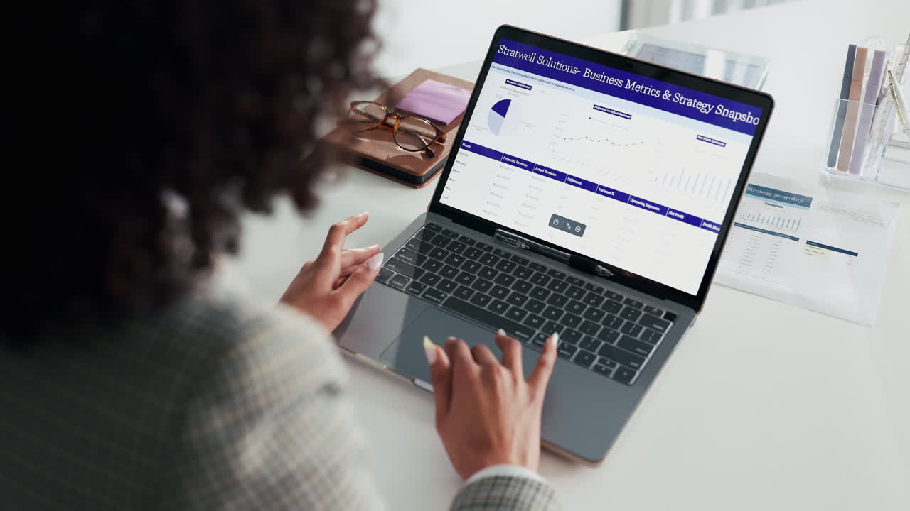 Woman Analyzing Financial Data on Laptop