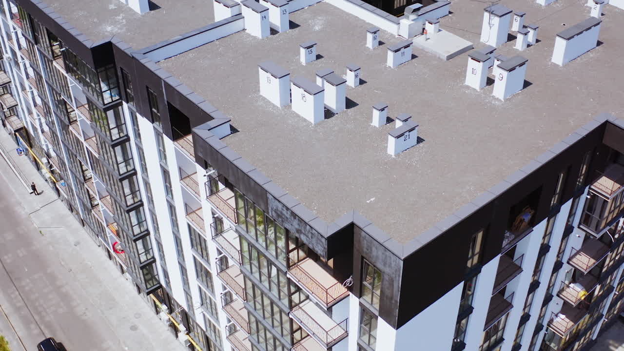 Contemporary exterior of high-raised building. New public housing apartments in the city of modern design. Motion camera top down.