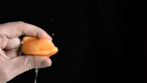 orange being squeezed in super slow motion