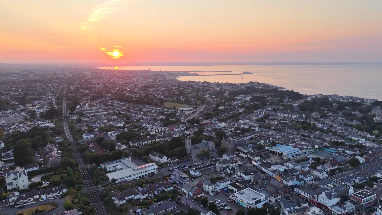 Mørkt luftfoto af Dublins bybillede fra South Dublin mod Dublin Bugt under dramatisk sollys