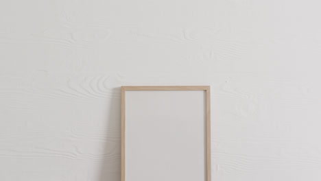 wooden frame with copy space on white background and white wall