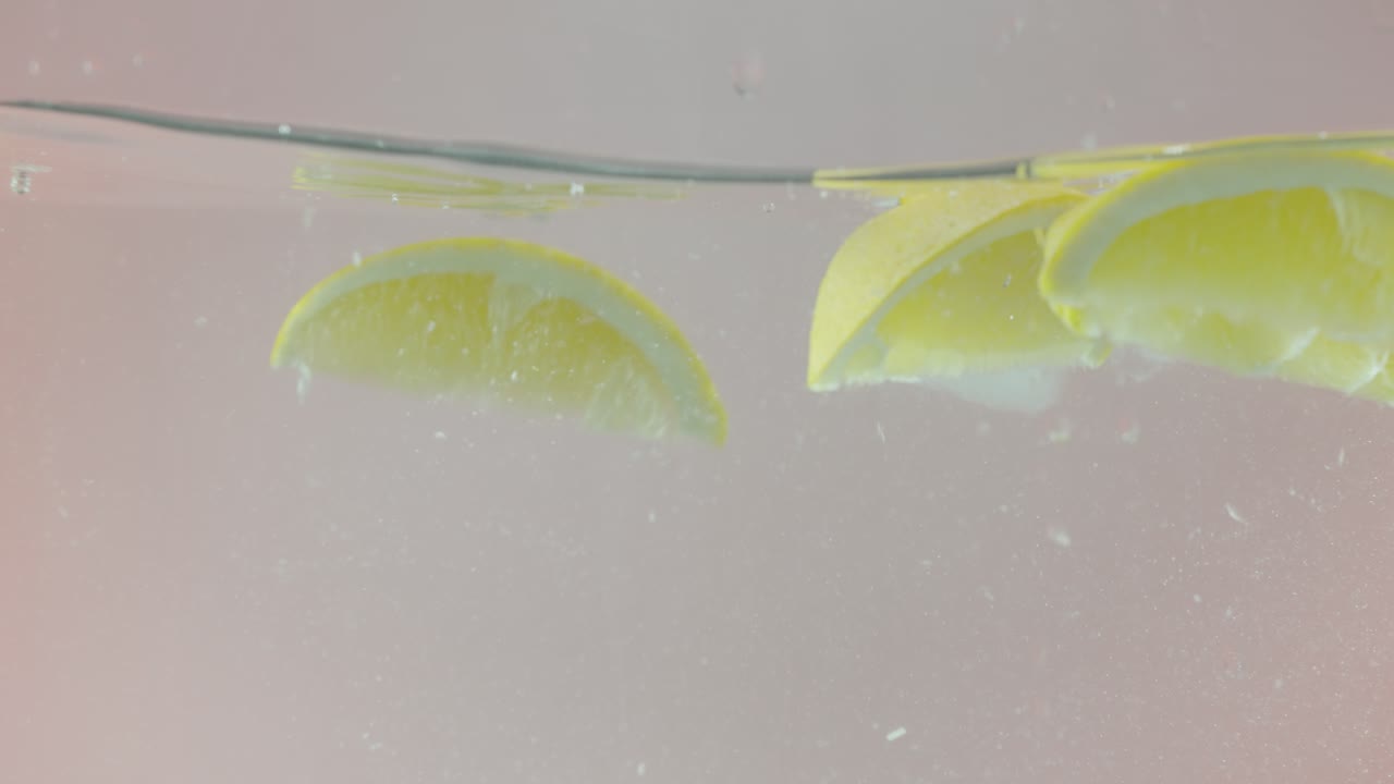 레몬 조각이 물에 어지고 있습니다.