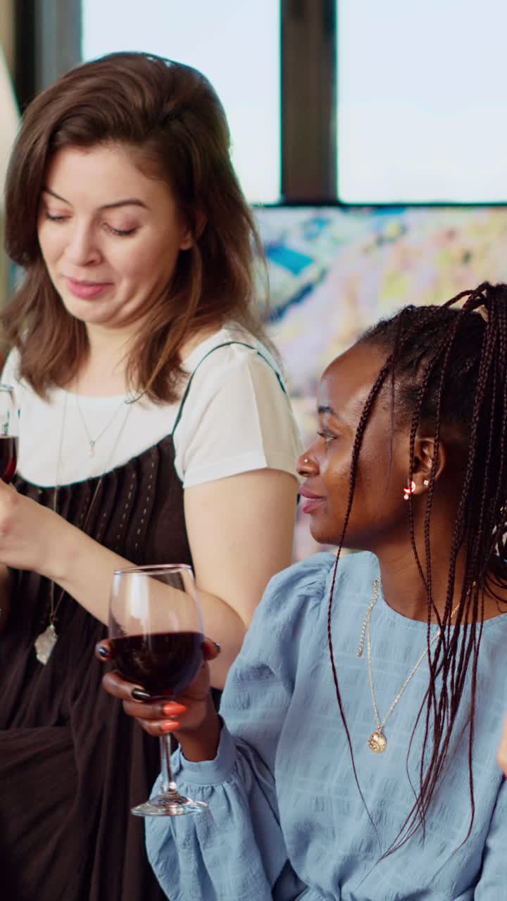 Vertical video BIPOC group of people having lively conversation at home, entertaining each other